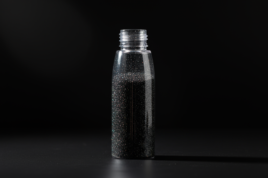 Plastic bottle of black glitter on black background