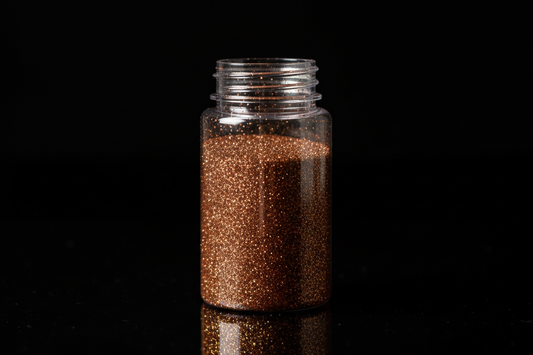 Plastic bottle of brown glitter on black background