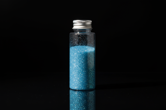 Plastic bottle of light blue glitter on black background