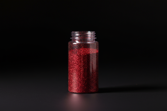 Plastic bottle of red glitter on black background